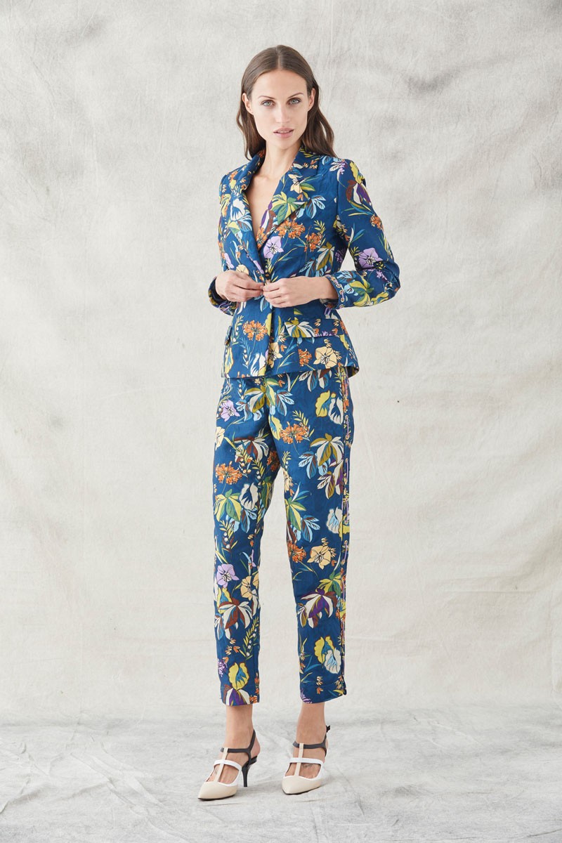 traje dos piezas para invitadas de bodas eventos fiestas nochevieja de apparentia pantalon pitillo y chaqueta con ollados en los laterales y cordones de antelina malva en tejido jacquard con fondo azul oscuro y un precioso estampado de flores