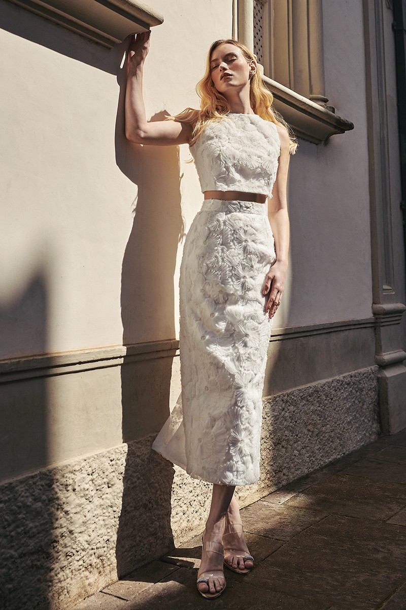 Espectacular conjunto de novia compuesto por falda recta midi y top corto confeccionado en tul fantasía con flores bordadas en relieve y pailletes color blanco de gran calidad.